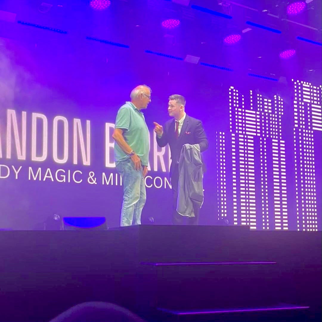 Brandon Barrett with an audience participant on stage