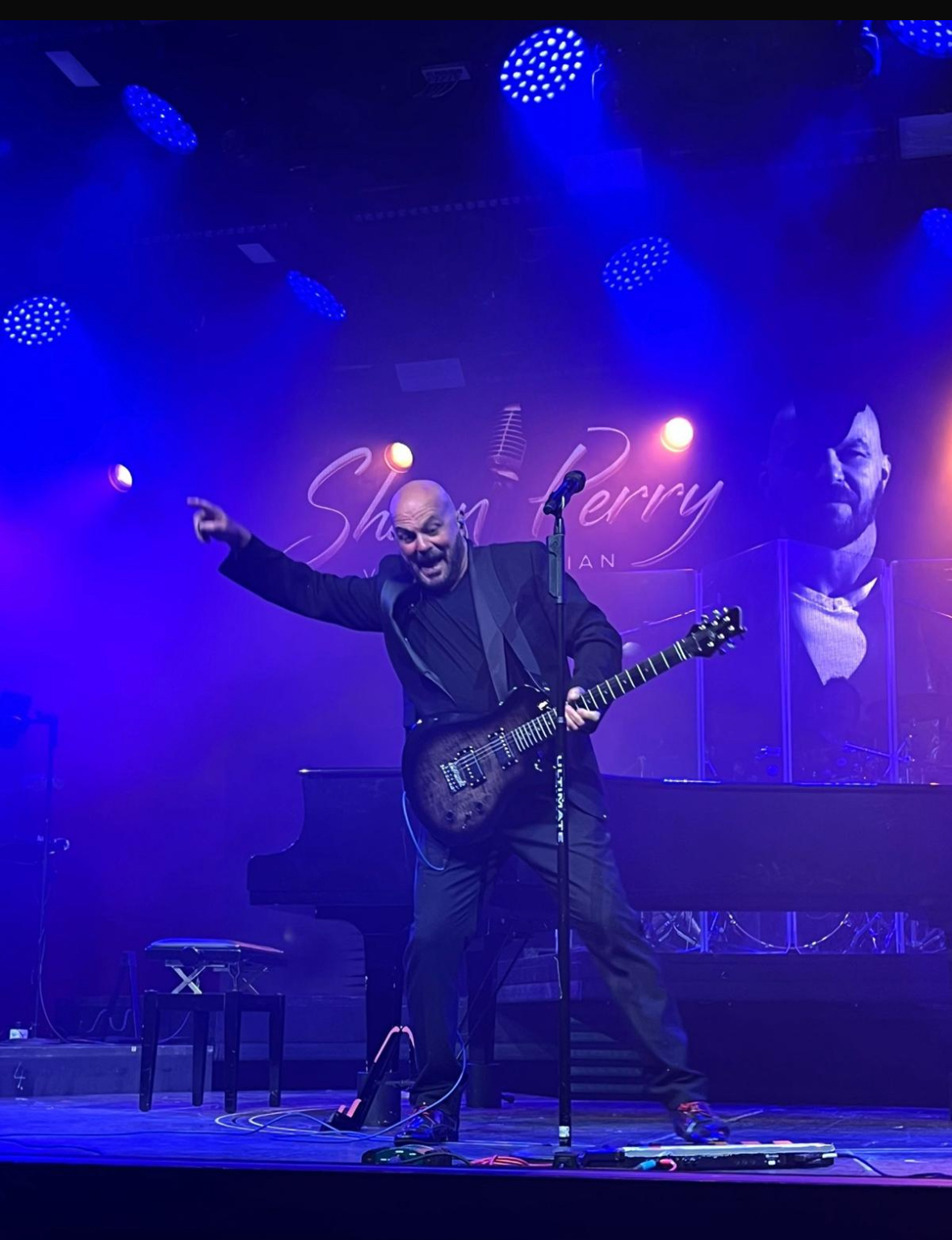 Shaun Perry engaging with the audience during a live guitar performance