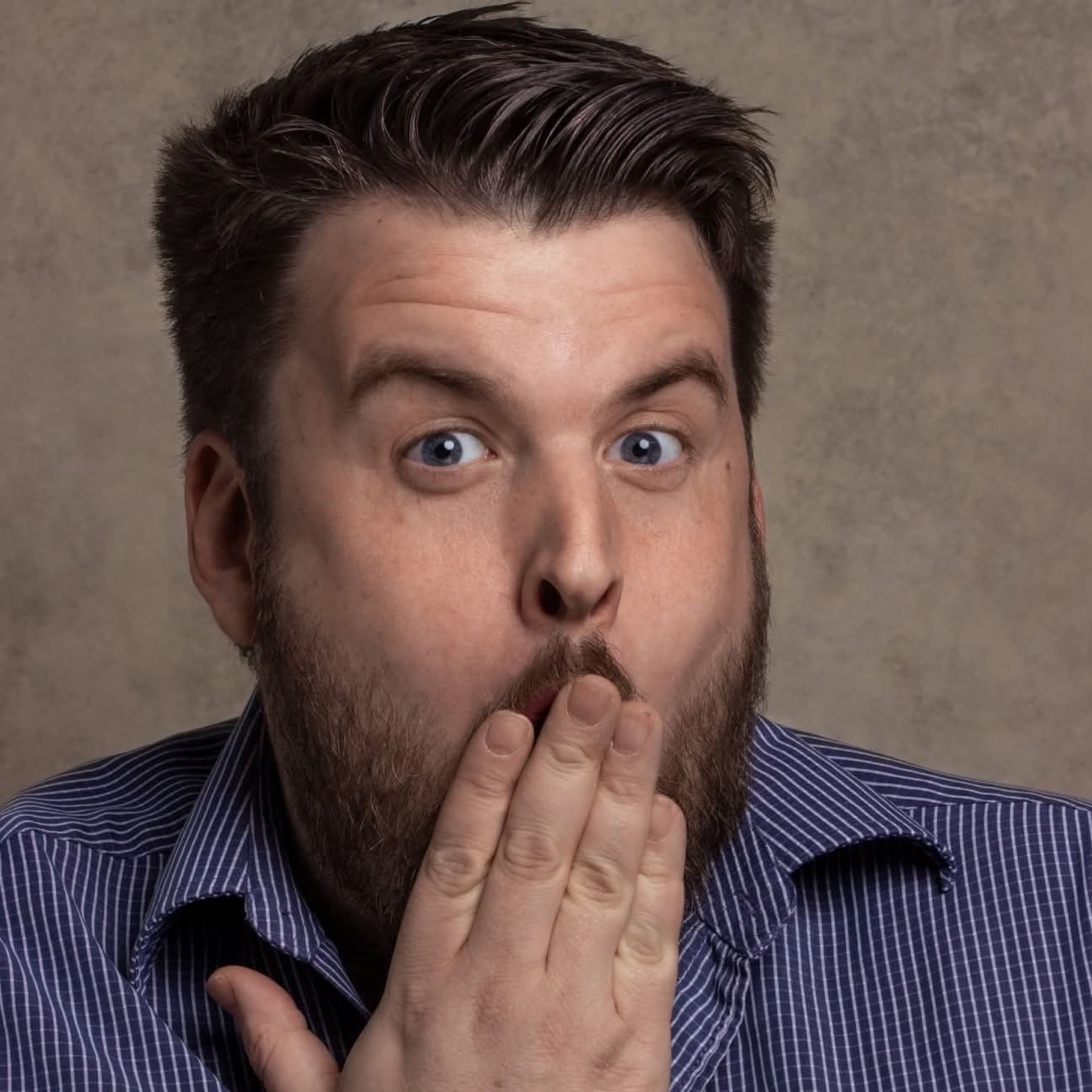 A comedy magician pulling a mock-astonished face to camera